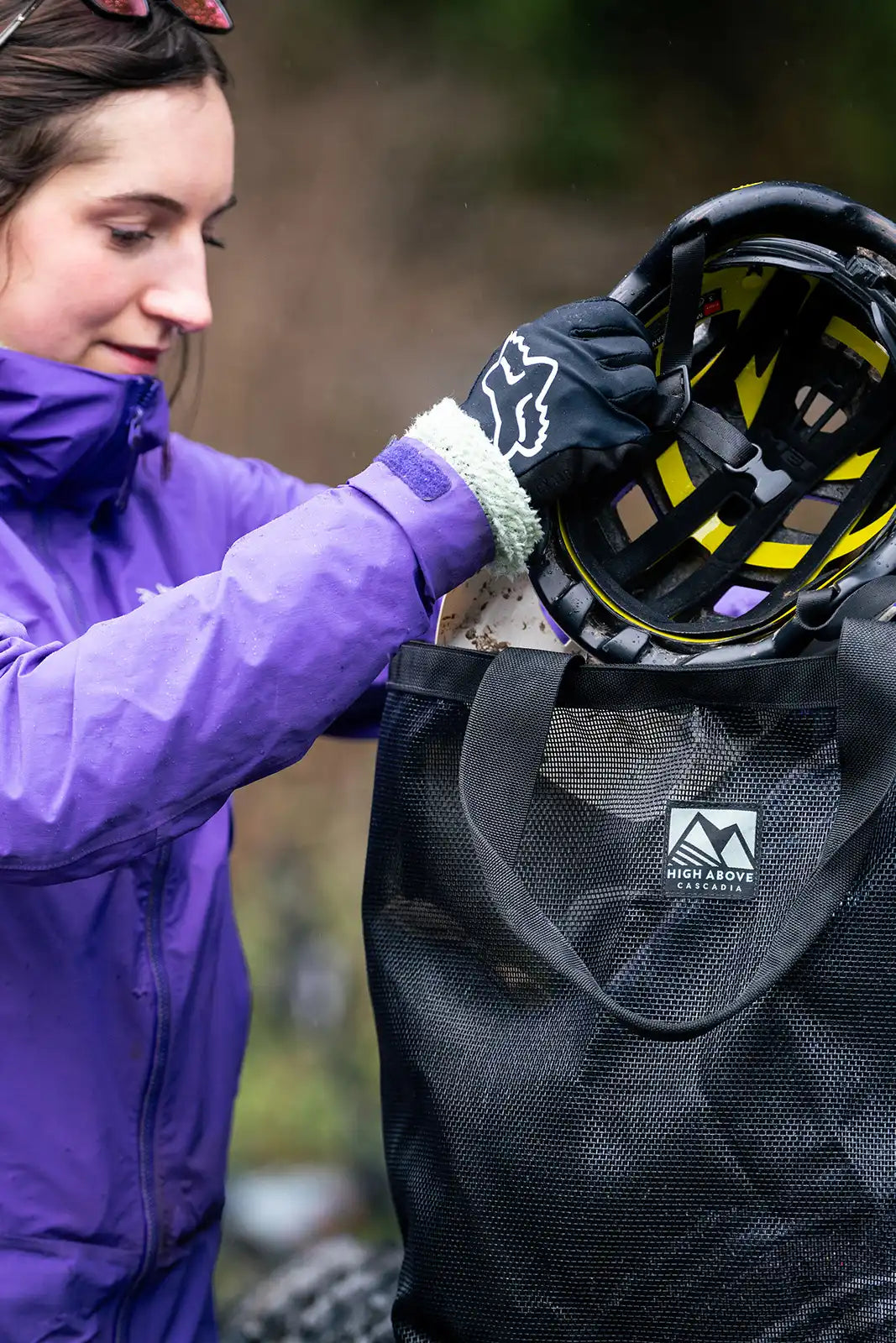 Woman loading mountain bike helmet into High Above Lost Lake Tote Bag