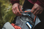Close up of person attaching keys to key clip inside High Above Supernatural Hydration Vest Pack