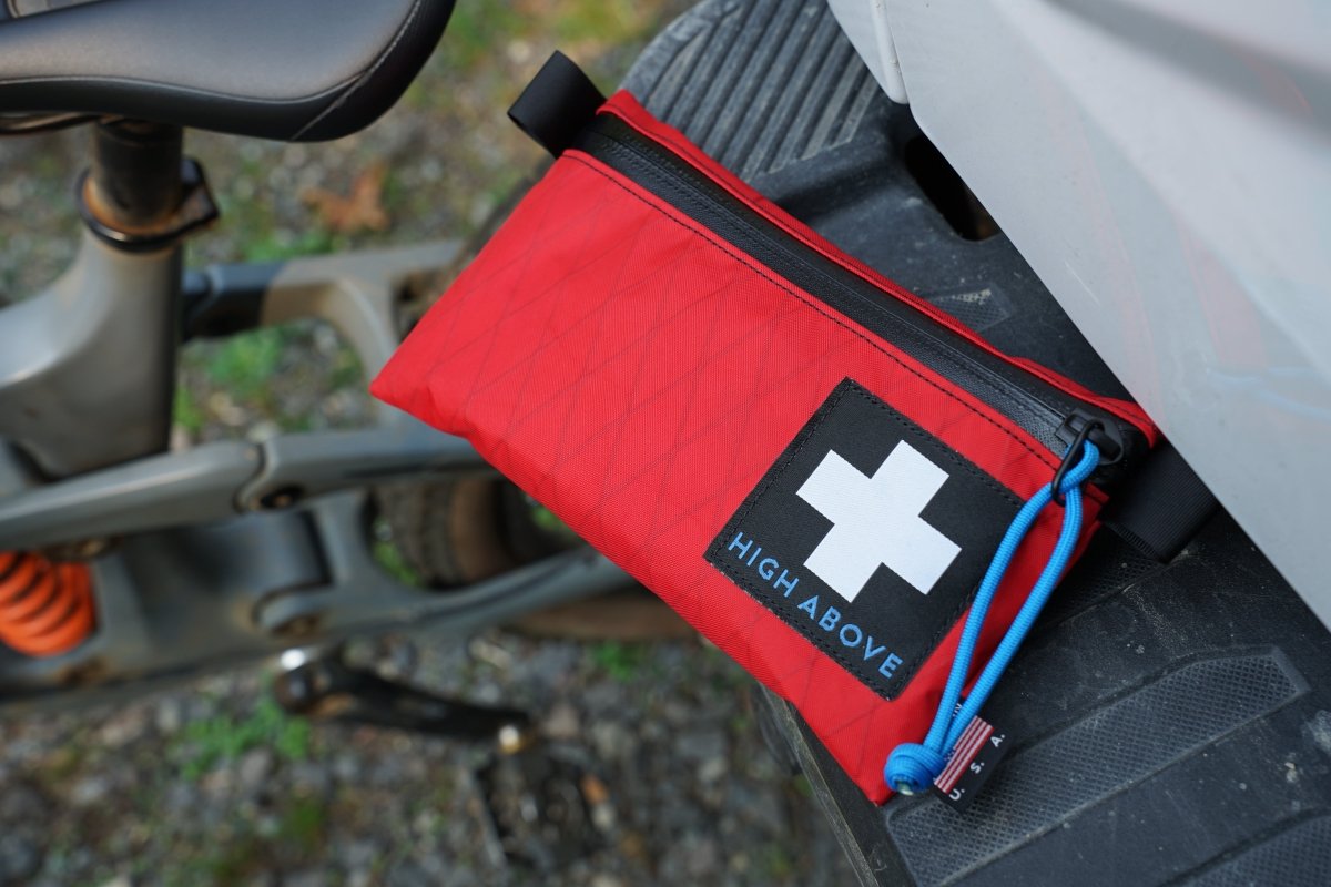 High Above Trail First Aid Kit with mountain bike in background.