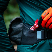 Person removing a snack from the side pocket of the High Above Venture 3D Hip Pack